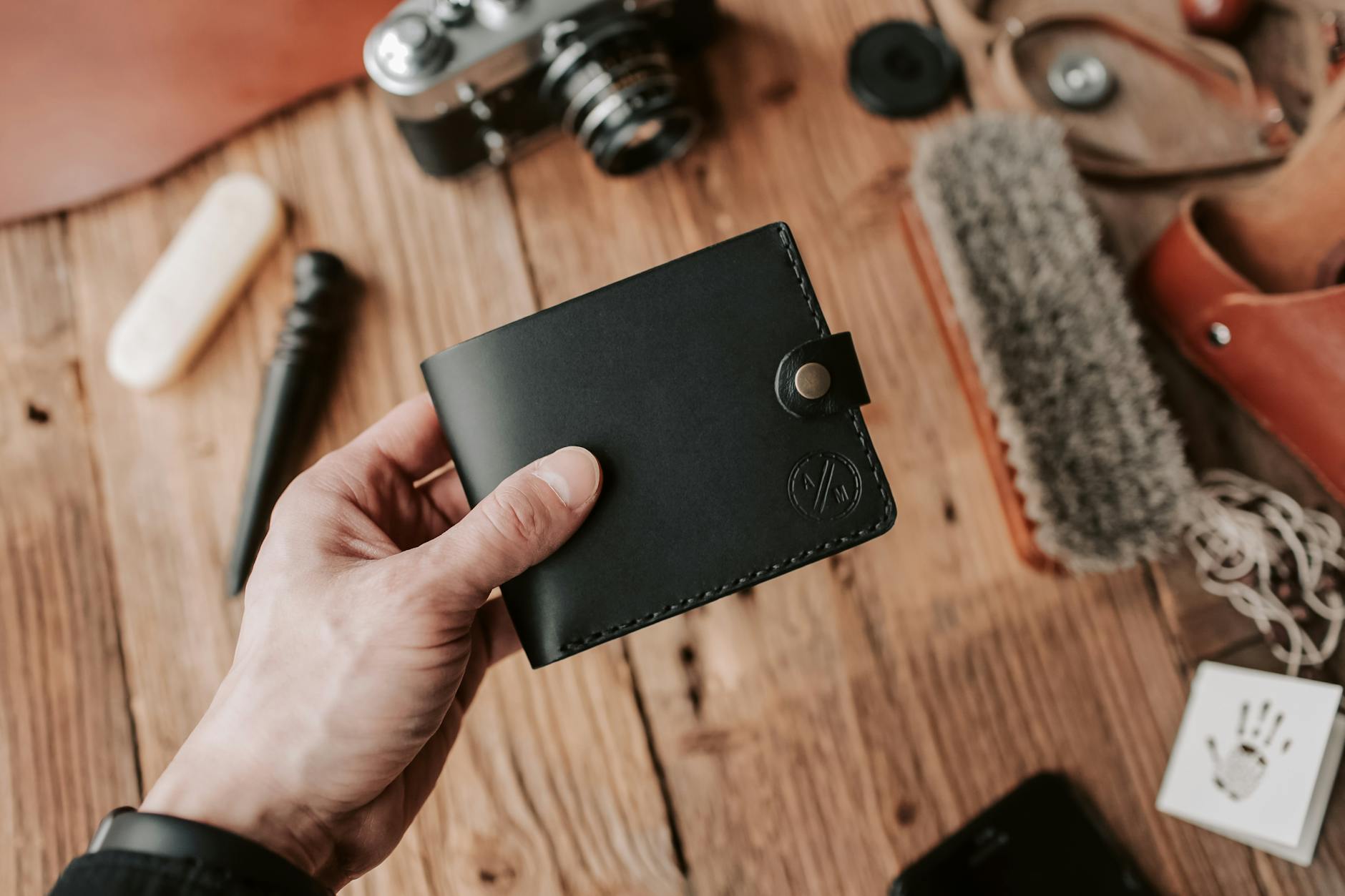 shallow focus photo of person holding black leather wallet