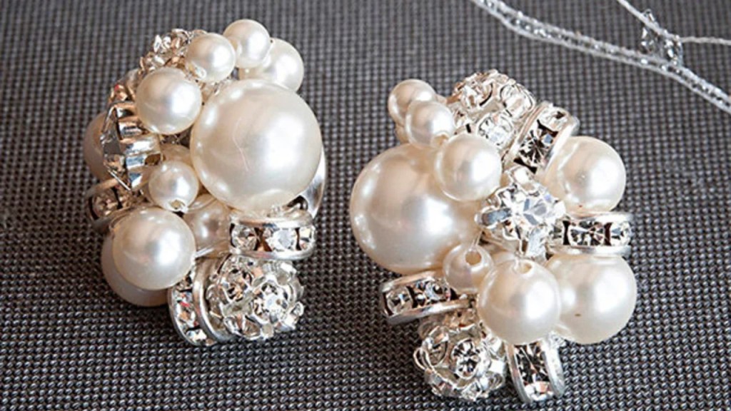 Close-up of a pair of elegant cluster earrings featuring multiple gemstones arranged in a floral pattern, set in a silver base. The vibrant colors of the gems create a sparkling effect, perfect for enhancing any formal or casual outfit.