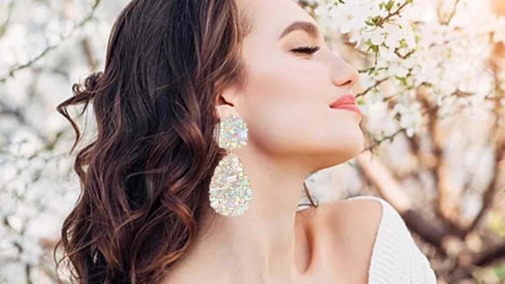 Elegant statement drop earrings featuring a bold and eye-catching design. The earrings have intricate detailing with a long, dangling form, showcasing a mix of gemstones and metalwork, making them perfect for a glamorous evening look. These earrings are designed to add sophistication and a modern edge to any outfit, with a luxurious finish that enhances their appeal.