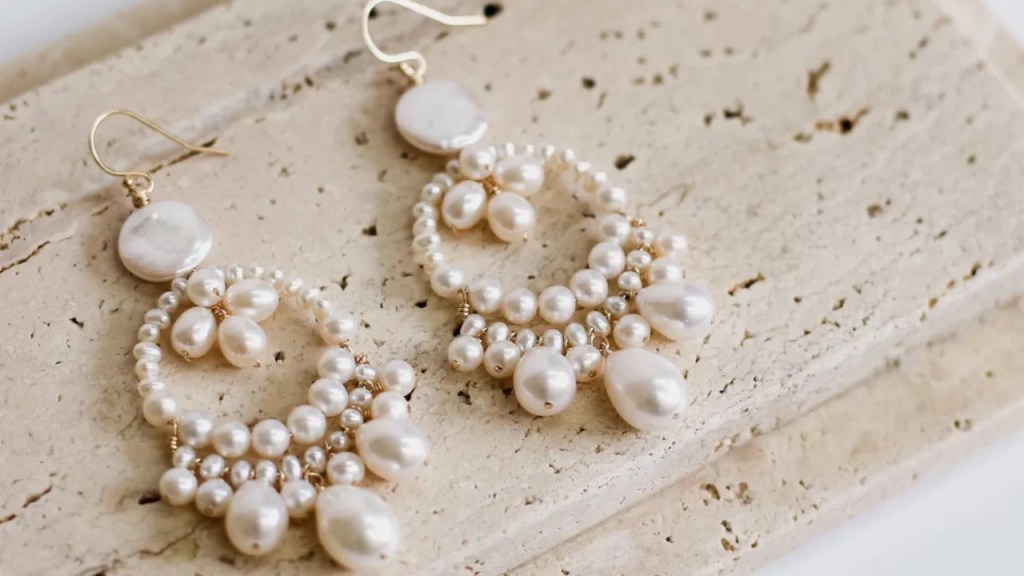 Elegant pearl earrings featuring lustrous white pearls, delicately set in silver hooks. The smooth surface of the pearls catches the light, adding a touch of timeless sophistication to any outfit. Perfect for both casual wear and formal occasions.