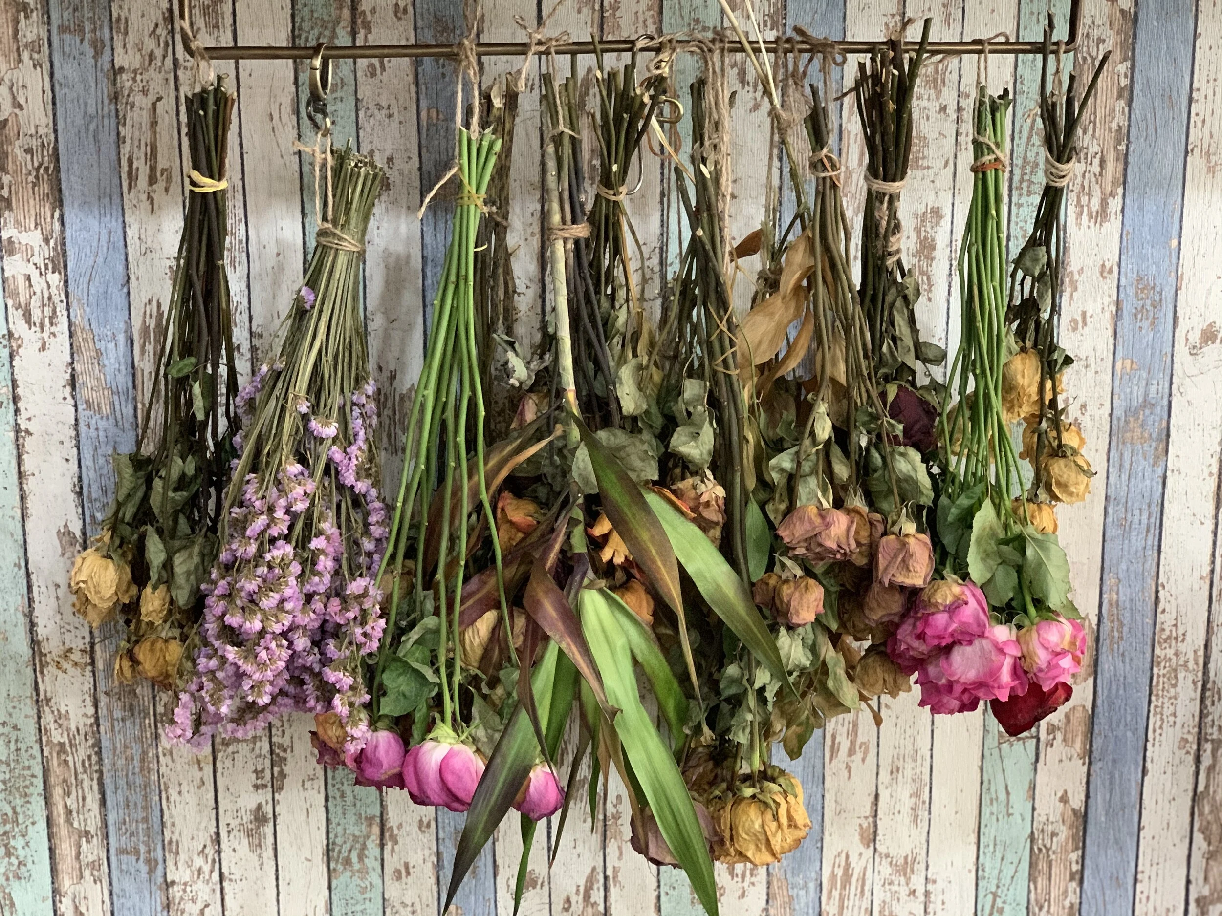An elegant, dried wedding bouquet arranged on a rustic wooden surface, showcasing preserved flowers with soft, muted colors, perfect for wedding reception decorations on a budget.
